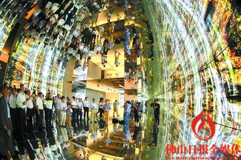 参加研讨会的嘉宾们在参观金意陶新总部展厅的“魔法世界”，通过全方位的视听、空间等交互方式构筑一个具有未来感、科技感的空间。